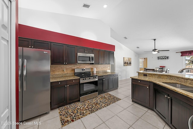100 Matthews St, Satellite Beach, FL 32937 - kitchen with appliances with stainless steel finishes, a ceiling fan, backsplash, light tile patterned flooring, and light stone countertops