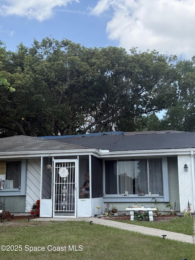 1455 Sawin Ct NE, Palm Bay, FL 32905 - view of front facade with a sunroom and a front lawn