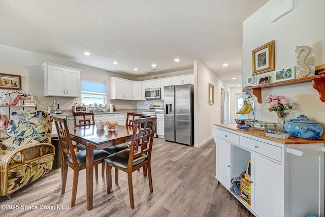 1689 Colorado St SE, Palm Bay, FL 32909 - dining area featuring light wood finished floors, a textured ceiling, and recessed lighting