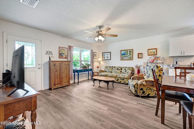 1689 Colorado St SE, Palm Bay, FL 32909 - living area featuring light wood-type flooring, a textured ceiling, and ceiling fan