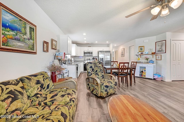 1689 Colorado St SE, Palm Bay, FL 32909 - living area featuring light wood-style flooring, a ceiling fan, a textured ceiling, and recessed lighting