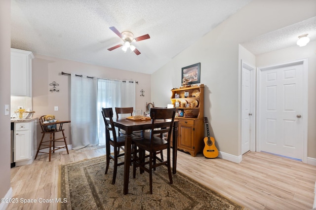 6640 Dock Ave, Cocoa, FL 32927 - dining area featuring a textured ceiling, light wood finished floors, ceiling fan, and vaulted ceiling