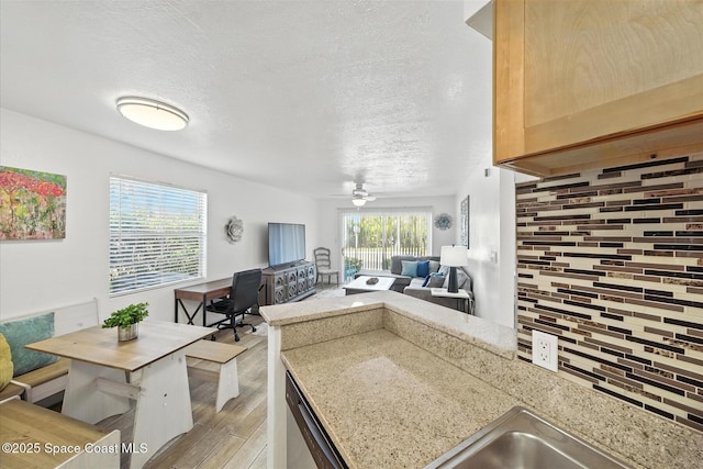 1951 Island Club Dr Unit 3-48, Melbourne, FL 32903 - kitchen with light wood-style floors, tasteful backsplash, open floor plan, a textured ceiling, and a peninsula