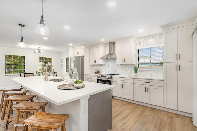 362 Nikomas Way, Melbourne Beach, FL 32951 - kitchen with wall chimney range hood, appliances with stainless steel finishes, a kitchen bar, a center island with sink, and backsplash