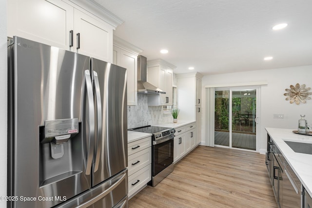362 Nikomas Way, Melbourne Beach, FL 32951 - kitchen with appliances with stainless steel finishes, wall chimney range hood, light countertops, light wood-type flooring, and decorative backsplash