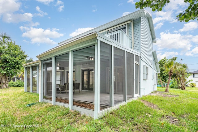 362 Nikomas Way, Melbourne Beach, FL 32951 - rear view of house featuring a sunroom, a lawn, and a balcony