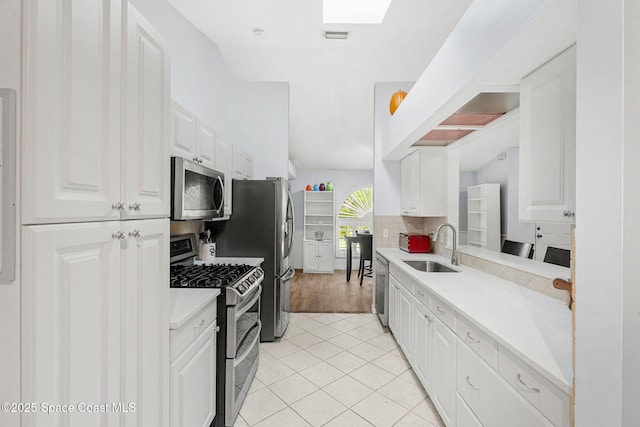 1745 Crane Creek Blvd, Melbourne, FL 32940 - kitchen with stainless steel appliances, light countertops, white cabinets, decorative backsplash, and light tile patterned floors