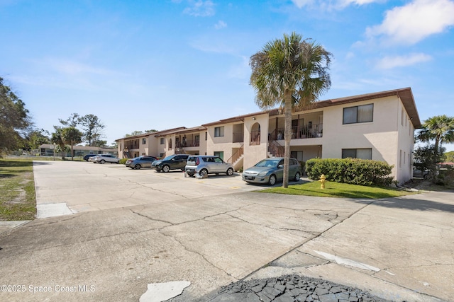 313 La Paloma Ln, Titusville, FL 32780 - view of building exterior with uncovered parking and a residential view