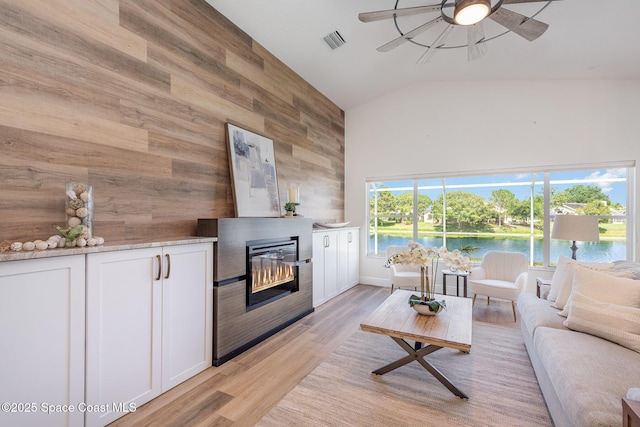 1471 Cypress Trace Dr, Melbourne, FL 32940 - living room with wooden walls, high vaulted ceiling, ceiling fan, light wood-style flooring, and a fireplace