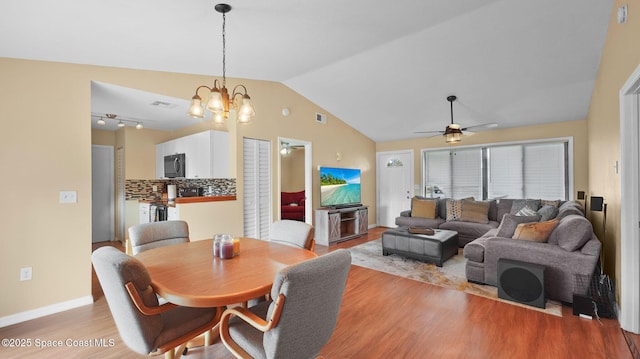 219 Fecco St, Cocoa, FL 32927 - dining room featuring light wood-style flooring, vaulted ceiling, a ceiling fan, and a chandelier