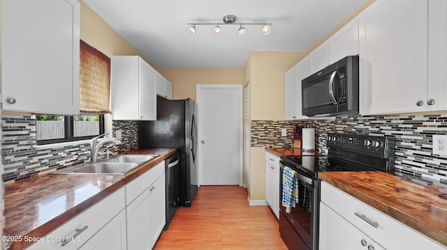 219 Fecco St, Cocoa, FL 32927 - kitchen featuring black range with electric stovetop, dishwashing machine, white cabinets, and light wood finished floors