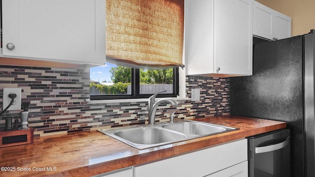 219 Fecco St, Cocoa, FL 32927 - kitchen featuring dishwashing machine, butcher block countertops, white cabinetry, backsplash, and freestanding refrigerator