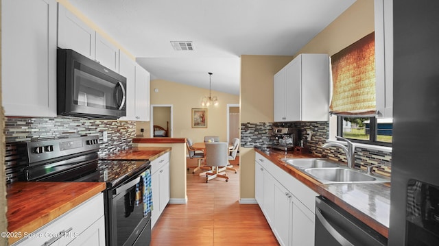 219 Fecco St, Cocoa, FL 32927 - kitchen with appliances with stainless steel finishes, white cabinetry, lofted ceiling, decorative backsplash, and pendant lighting