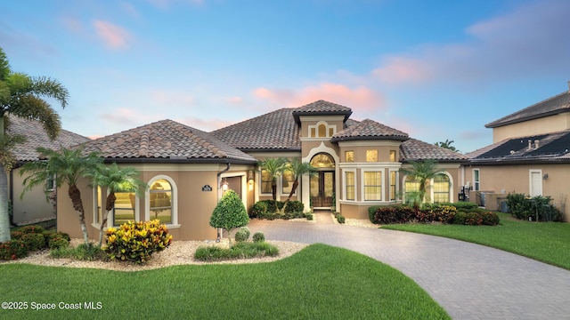 3079 Levanto Dr, Melbourne, FL 32940 - mediterranean / spanish home with curved driveway, stucco siding, a front yard, and a tile roof