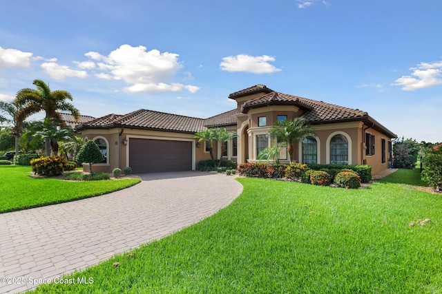 3079 Levanto Dr, Melbourne, FL 32940 - mediterranean / spanish house featuring decorative driveway, an attached garage, stucco siding, and a tile roof