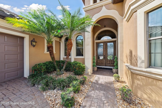 3079 Levanto Dr, Melbourne, FL 32940 - view of exterior entry featuring french doors, stucco siding, and an attached garage