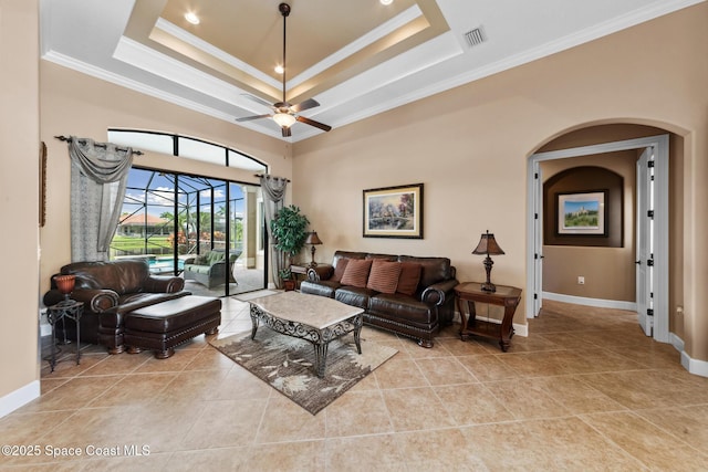 3079 Levanto Dr, Melbourne, FL 32940 - living area featuring ornamental molding, arched walkways, light tile patterned flooring, a raised ceiling, and ceiling fan