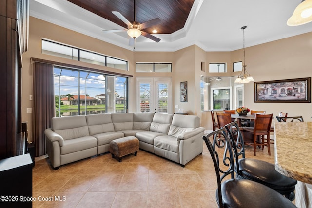 3079 Levanto Dr, Melbourne, FL 32940 - living room with a raised ceiling, light tile patterned flooring, crown molding, ceiling fan, and a towering ceiling