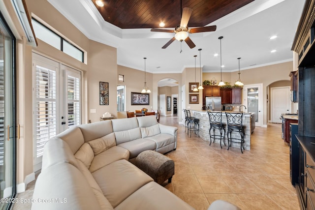 3079 Levanto Dr, Melbourne, FL 32940 - living room with arched walkways, a ceiling fan, a raised ceiling, light tile patterned floors, and wooden ceiling