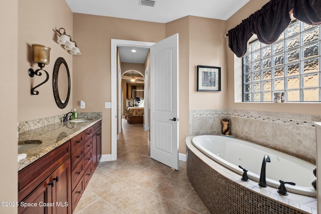 3079 Levanto Dr, Melbourne, FL 32940 - full bath with a tub with jets, double vanity, ensuite bathroom, and tile patterned floors