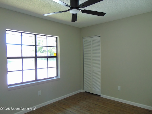 1943 Bradway St NE, Palm Bay, FL 32905 - unfurnished bedroom with a closet, dark wood-style floors, a ceiling fan, and a textured ceiling