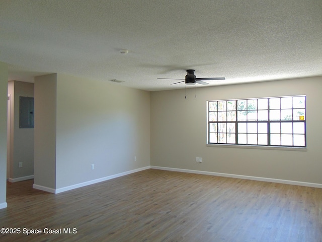 1943 Bradway St NE, Palm Bay, FL 32905 - spare room with wood finished floors, ceiling fan, electric panel, and a textured ceiling