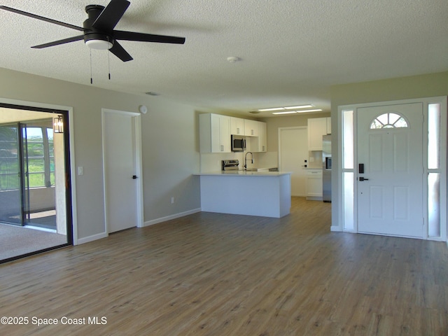 1943 Bradway St NE, Palm Bay, FL 32905 - unfurnished living room featuring a textured ceiling, wood finished floors, and a ceiling fan