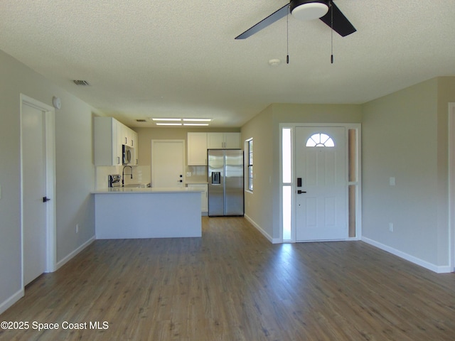 1943 Bradway St NE, Palm Bay, FL 32905 - kitchen with stainless steel appliances, wood finished floors, light countertops, open floor plan, and a peninsula