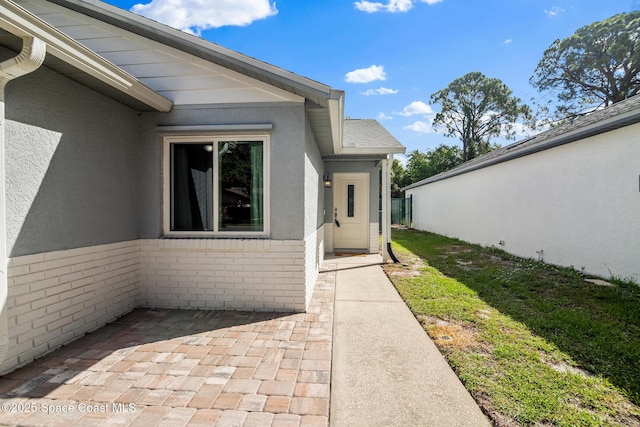 3104 Winchester Dr, Cocoa, FL 32926 - doorway to property featuring brick siding, a patio, and stucco siding