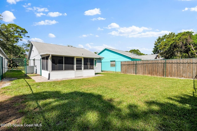 3104 Winchester Dr, Cocoa, FL 32926 - back of house with a sunroom, a gate, a fenced backyard, and a shingled roof