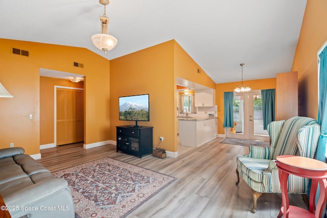3104 Winchester Dr, Cocoa, FL 32926 - living room featuring light wood-style flooring, a chandelier, and high vaulted ceiling