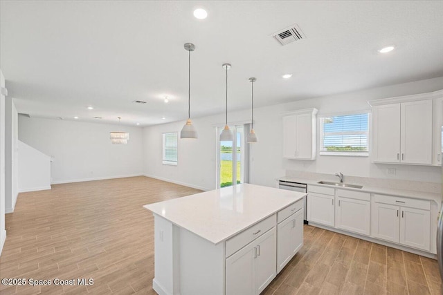 3538 Angler Dr, Ft Pierce, FL 34947 - kitchen featuring light wood finished floors, light countertops, white cabinets, a kitchen island, and recessed lighting