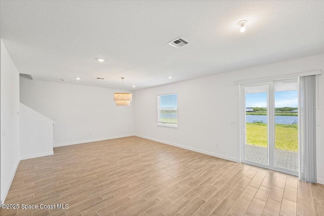 3538 Angler Dr, Ft Pierce, FL 34947 - unfurnished room featuring light wood-style floors, a water view, recessed lighting, and a textured ceiling