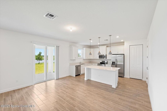 3538 Angler Dr, Ft Pierce, FL 34947 - kitchen featuring appliances with stainless steel finishes, light countertops, light wood-style floors, white cabinetry, and recessed lighting