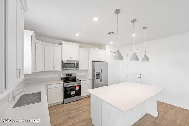 3538 Angler Dr, Ft Pierce, FL 34947 - kitchen featuring appliances with stainless steel finishes, light wood-style floors, a kitchen island, light countertops, and recessed lighting
