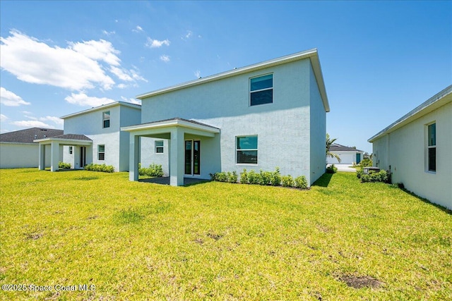 3538 Angler Dr, Ft Pierce, FL 34947 - rear view of property with stucco siding and a lawn