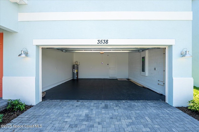 3538 Angler Dr, Ft Pierce, FL 34947 - garage featuring water heater, decorative driveway, and electric panel