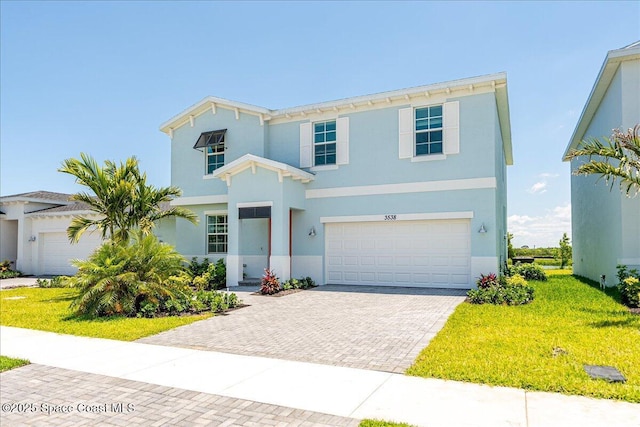 3538 Angler Dr, Ft Pierce, FL 34947 - view of front facade with decorative driveway, an attached garage, stucco siding, and a front yard