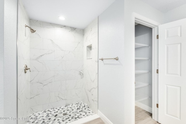 338 Mott St SW, Palm Bay, FL 32908 - full bathroom with a tile shower, a walk in closet, wood finished floors, and recessed lighting
