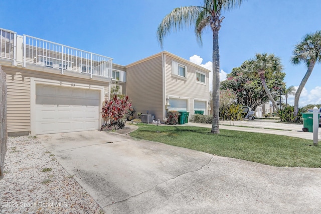 53 Emerald Ct, Satellite Beach, FL 32937 - view of property exterior featuring a garage, a balcony, driveway, and a yard