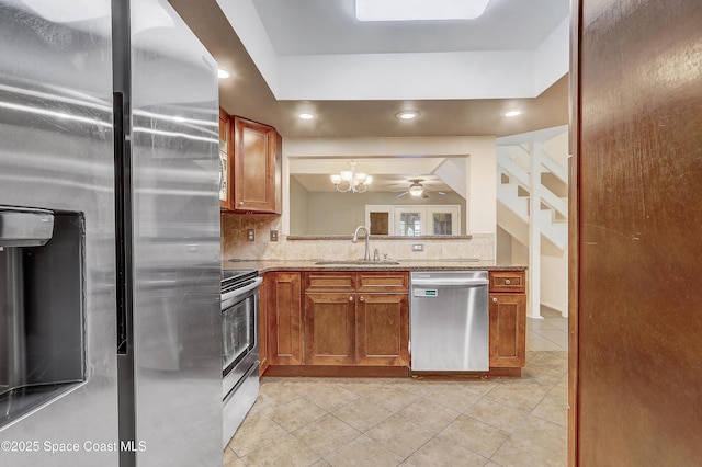 53 Emerald Ct, Satellite Beach, FL 32937 - kitchen featuring appliances with stainless steel finishes, backsplash, light tile patterned floors, brown cabinetry, and light stone counters