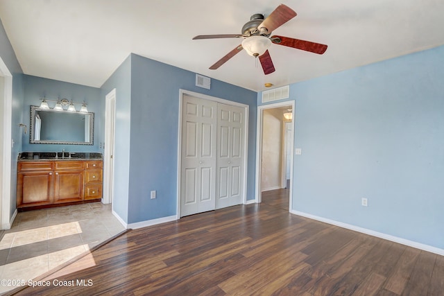 53 Emerald Ct, Satellite Beach, FL 32937 - unfurnished bedroom with light wood finished floors, a closet, ceiling fan, and ensuite bathroom