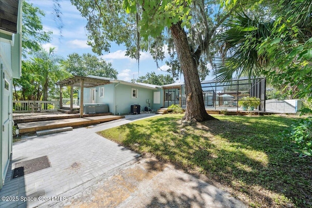 2310 Bignonia St, Melbourne, FL 32901 - view of yard with a jacuzzi, a patio area, a pergola, and glass enclosure