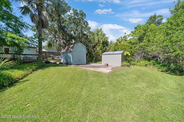 2310 Bignonia St, Melbourne, FL 32901 - view of grassy yard featuring a storage shed, a deck, and a barn