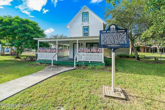 2310 Bignonia St, Melbourne, FL 32901 - view of front of house featuring covered porch and a front yard