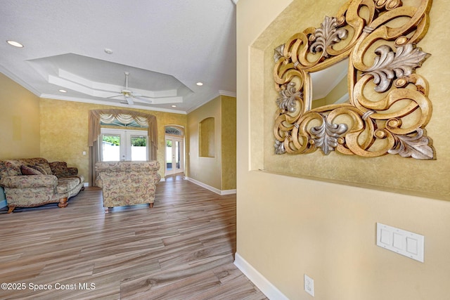 2604 Canary Isles Dr, Melbourne, FL 32901 - corridor featuring a tray ceiling, ornamental molding, arched walkways, wood finished floors, and recessed lighting