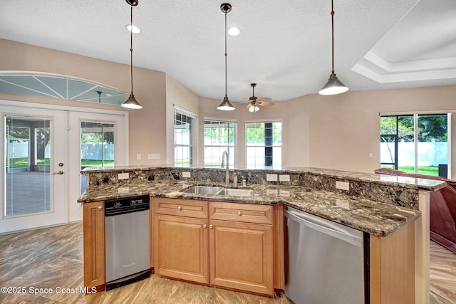 2604 Canary Isles Dr, Melbourne, FL 32901 - kitchen featuring dishwasher, open floor plan, ceiling fan, dark stone countertops, and hanging light fixtures