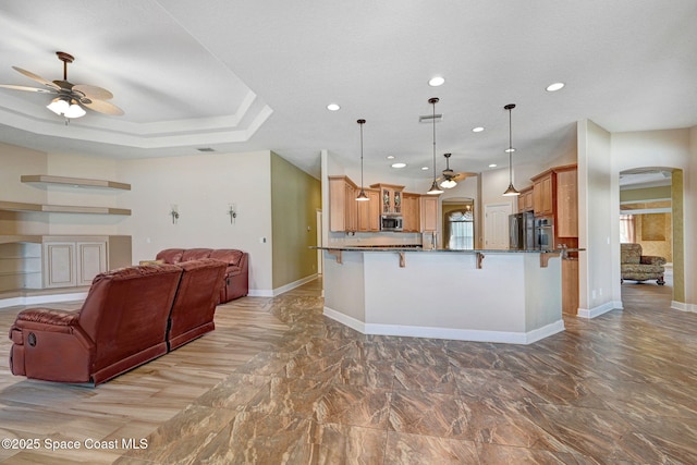 2604 Canary Isles Dr, Melbourne, FL 32901 - kitchen with stainless steel microwave, a ceiling fan, open floor plan, arched walkways, and refrigerator