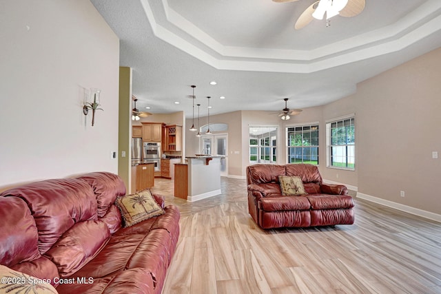 2604 Canary Isles Dr, Melbourne, FL 32901 - living room featuring ceiling fan, a tray ceiling, recessed lighting, and light wood-style flooring