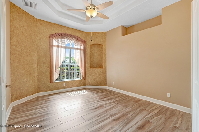 2604 Canary Isles Dr, Melbourne, FL 32901 - unfurnished room featuring light wood-style flooring, ceiling fan, and a raised ceiling